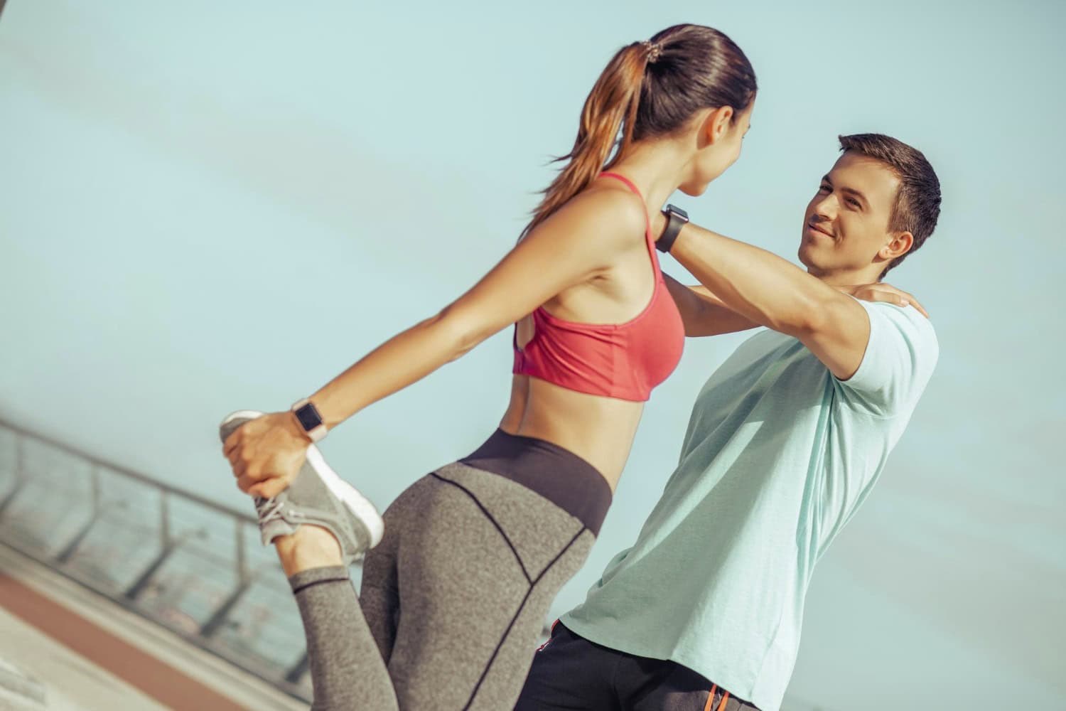 Couple exercising outdoors, supporting each other for fitness and wellness improvement